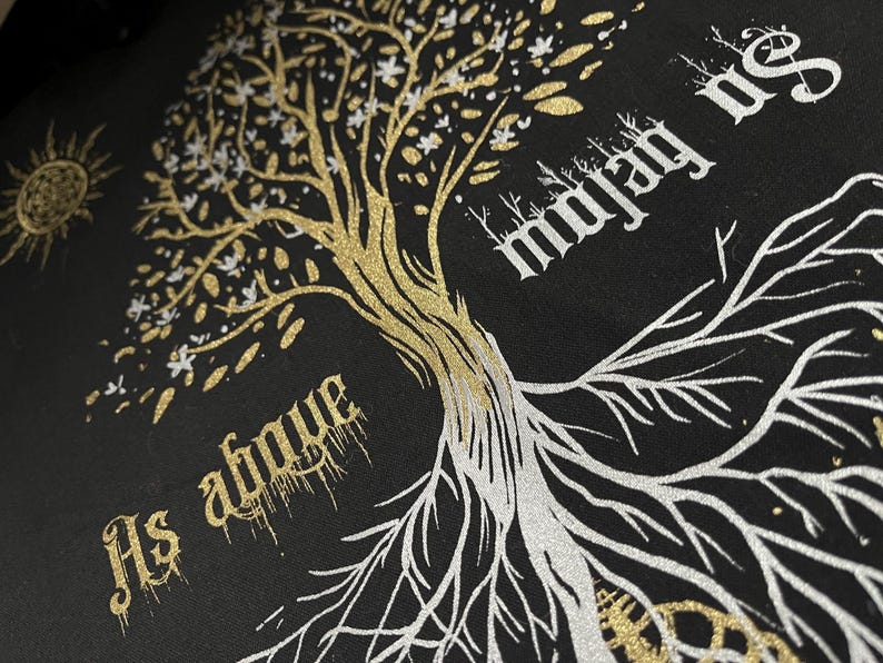 May include: A black t-shirt with a gold and silver glitter design of a tree with the text "As above so below" and "majesty" on either side of the tree.
