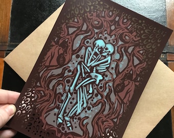 May include: A dark red and blue print of two skeletons embracing in a forest setting. The skeletons are outlined in blue and the forest is filled with dark red vines and leaves. The background is a dark brown with gold flecks.