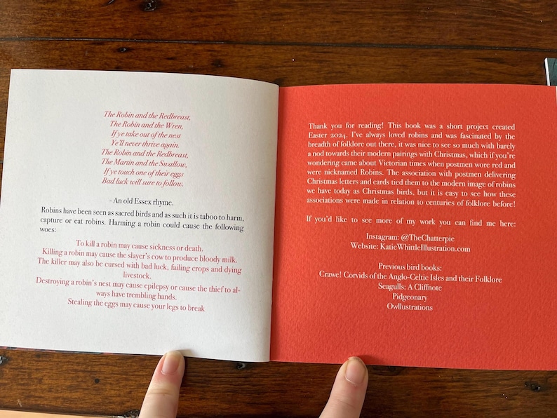 May include: Open book with red and white text on a white background. The left page has a poem about robins and the right page has information about the author and their other books. The text on the right page includes the title "Previous bird books" and the names of other books by the author.