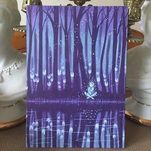 May include: A purple and blue illustration of a forest with a small figure sitting in the middle of a reflecting pool. The figure is surrounded by glowing white orbs.