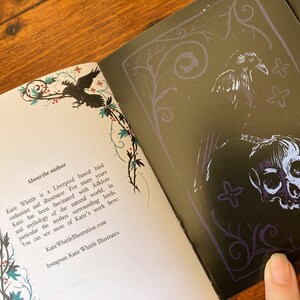 May include: An open book with a black and white illustration of a raven and a skull on the right page. The left page has text about the author, Katie Whittle, a Liverpool-based bird enthusiast and illustrator. The text mentions her fascination with folklore and mythology, particularly surrounding birds. The book's cover features a decorative border with vines and flowers.