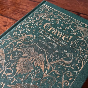 Puede incluir: Un libro verde con letras doradas e ilustraciones de pájaros y vides. El título es "Grawe! Corvids of the Anglo-Celtic Isles and their Folklore" de K.S. Whittle.