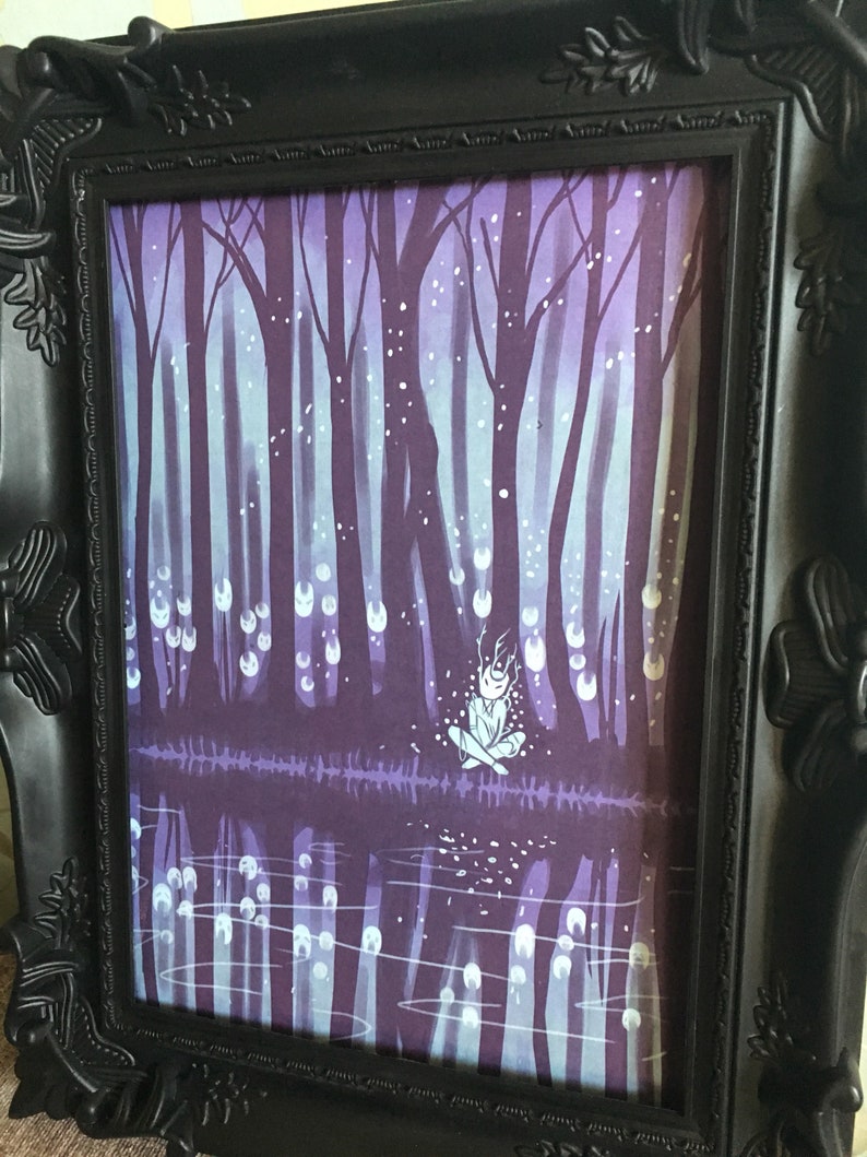 May include: A framed illustration of a figure sitting in a forest with a purple and blue color scheme. The figure is surrounded by glowing orbs and the forest is reflected in a body of water.