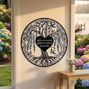 May include: A circular black metal wall art piece featuring a willow tree design with a central heart shape. The text reads 40th Anniversary, JENNY & STEVE, and 03.05.1986. The intricate cutout design includes branches, roots, and two flying birds.