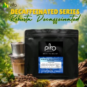 Pode incluir: Uma embalagem de café preta rotulada Piro Space Robusta Decaffeinated Natural com um peso de 500g, acompanhada por um filtro de café de metal contendo uma bebida castanho-clara e um pequeno monte de grãos de café torrados sobre madeira.