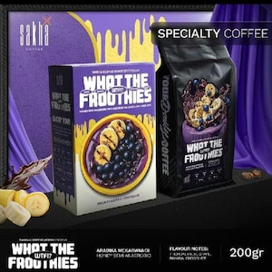 May include: A 200g box and a black bag of Sakha Coffee labelled What The Froothies. The packaging features purple and yellow graphics, text, and an illustration of a bowl containing sliced bananas and blueberries. The product is 200g.