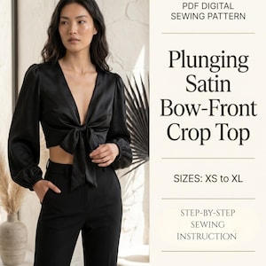 Op de afbeelding: Zwarte satijnen crop top met een diepe halslijn en strik aan de voorkant. De top heeft lange mouwen en wordt gecombineerd met een zwarte broek. De tekst luidt "Plunging Satin Bow-Front Crop Top" en "PDF Digital Sewing Pattern."