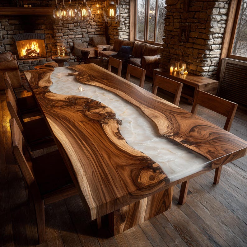 May include: A large, handcrafted wooden dining table with a river of white resin running through the center. The table is surrounded by wooden chairs and set in a rustic, well-lit dining room. The table measures approximately 120 inches long.