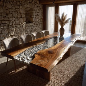May include: A bespoke dining table featuring a live edge wooden surface and a glass panel filled with pebbles. The table is supported by a wooden base and is surrounded by neutral-toned chairs. The room has a rustic, natural aesthetic.