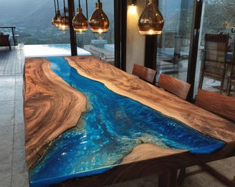 Mesa de comedor artesanal de nogal con resina epoxi y borde natural.