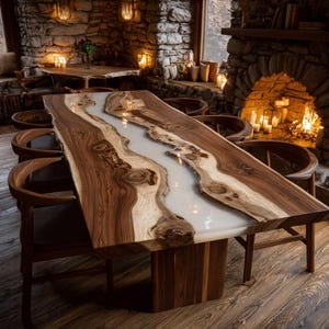 May include: A large, rectangular wooden dining table with a river of white resin running through the center. The table is supported by a solid wooden base and surrounded by wooden chairs. The table is approximately 100 inches long.