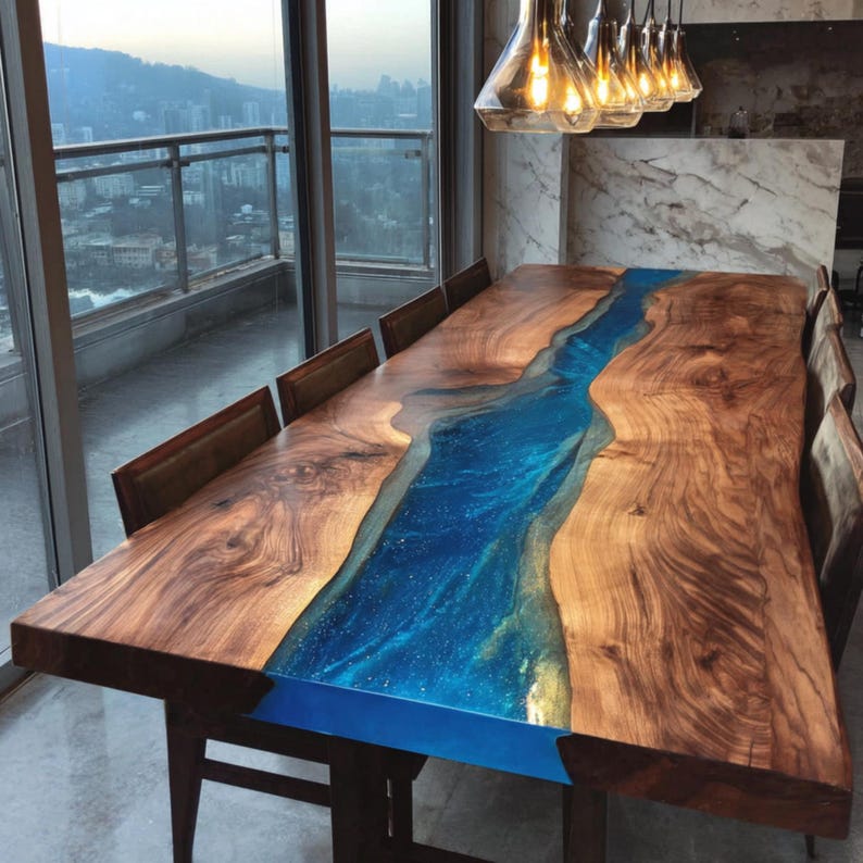 May include: A large, rectangular wooden dining table with a blue resin river running down the center. The table is surrounded by brown chairs and is in a room with a city view. The table is approximately 120 inches long.
