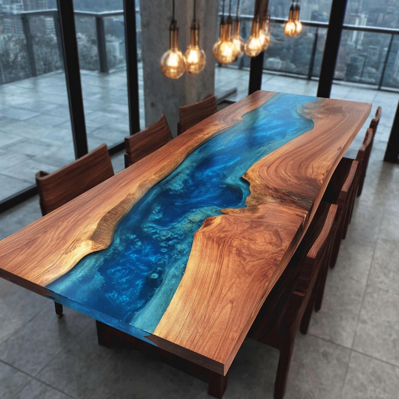 May include: A large wooden dining table with a blue epoxy resin river running through the center. The table is surrounded by wooden chairs. The table is approximately 100 inches long and 40 inches wide.