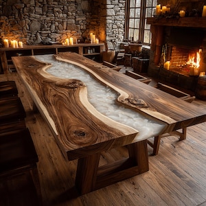 May include: A large, handcrafted wooden dining table with a river of white resin running through the center. The table has a natural wood grain finish and is supported by sturdy wooden legs. The room has a rustic, cozy atmosphere.