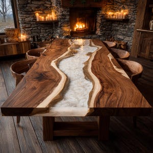May include: A large, rectangular wooden dining table with a river-like design. The table features a dark brown wood with a light-colored, stone-filled epoxy resin center. The table is supported by a sturdy wooden base and surrounded by wooden chairs.