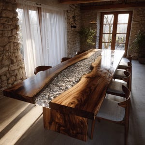 May include: A large, handcrafted wooden dining table with a river-like design. The table features a dark, polished wood surface with a central channel filled with smooth, gray river stones. The table is surrounded by wooden chairs.