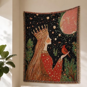 May include: A woven wall tapestry featuring a long-haired figure wearing a crown and a red dress, holding a red cardinal bird. The background depicts a dark night sky with a large pink moon, stars, and green trees, finished with a fringed edge.