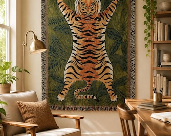 May include: A rectangular woven throw blanket featuring a large, centered tiger illustration with orange, black, and white fur against a dark olive green background filled with dark green tropical leaf patterns and a fringed edge on all sides.