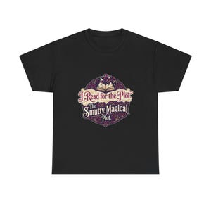 May include: A black short-sleeved t-shirt featuring a circular graphic with an open book and potion bottles. The text reads: I Read for the Plot. The Smutty, Magical Plot. The design uses cream, purple, and dark red colours with ornate flourishes.