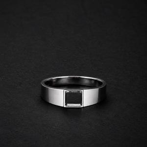 Könnte beinhalten: Ein polierter silberfarbener Metallring mit flachem Banddesign und einem markanten, mittig platzierten quadratischen Ausschnitt. Der Ring hat eine glatte, reflektierende Oberfläche und eine gleichmäßige Breite, was ein geometrisches Design unterstreicht.