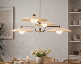 May include: A multi-arm chandelier featuring a central brass rod and four horizontal arms extending outward. Each arm supports a wide, shallow, off-white saucer-shaped shade with a small, spherical, frosted white light bulb centered underneath.