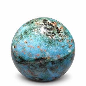 Può includere: Una pietra sferica lucida caratterizzata da un mix vibrante di tonalità turchese e blu intenso, accentuato da inclusioni minerali nere sparse e piccole macchie color rame brillante su tutta la superficie liscia e arrotondata.