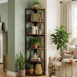 Puede incluir: Estantería esquinera de cinco niveles, hecha de metal oscuro y madera. Los estantes están llenos de libros, plantas y objetos decorativos. La estantería está en un salón con una pared verde y un sofá beige.