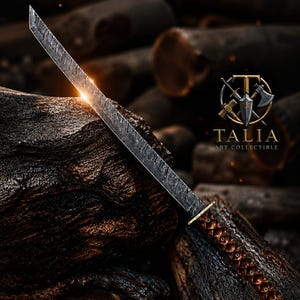Pode incluir: Espada de aço artesanal com lâmina texturizada e cabo castanho com padrão de losangos. A espada apresenta uma guarda dourada e repousa sobre uma superfície de madeira escura e texturizada. O texto "TALIA ART COLLECTIBLE" é visível.