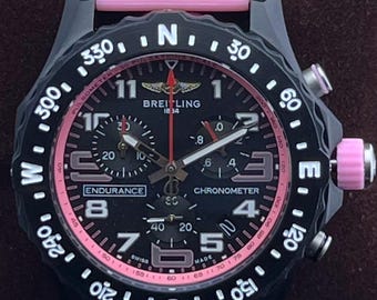 Orologio da polso vintage Breitling 1884 Endurance Pro Chronometer al quarzo con quadrante nero, cinturino in caucciù rosa, cassa nera, lunetta girevole e datario/subsecondi.