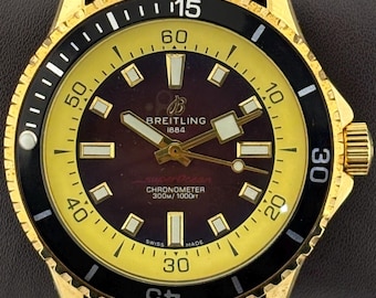 Orologio da polso vintage Breitling 1884 Super-Ocean con movimento automatico, quadrante marrone-oro, cinturino in caucciù marrone, cassa in oro e lunetta girevole, da uomo.