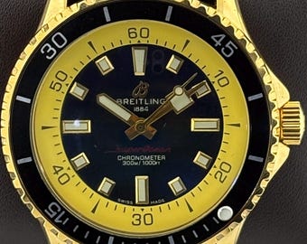 Orologio da polso vintage Breitling 1884 Super-Ocean con movimento automatico, quadrante nero-oro, cinturino in caucciù verde, cassa in oro e lunetta girevole, da uomo.