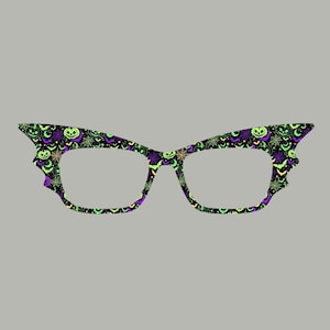 May include: Cat-eye shaped glasses frames featuring a black background with a repeating pattern of green jack-o'-lanterns, purple bats, and orange spiderwebs. The frames have a distinct pointed outer edge and a smooth, matte-like finish.