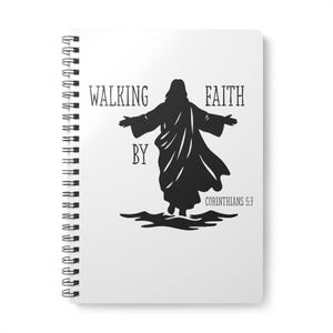 Puede incluir: Un cuaderno blanco con espiral con las palabras "WALKING BY FAITH" y una silueta negra de una figura con los brazos extendidos. También se ve el texto "CORINTHIANS 5:7".