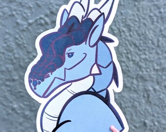 May include: A die-cut sticker featuring a stylised illustration of a dragon head and neck. The dragon is coloured in shades of light blue and dark blue, with a textured, dark blue scale pattern on its snout and forehead, and white horns.