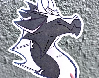 May include: A die-cut sticker featuring a stylised dragon head in profile. The dragon has dark grey scales, a white underbelly, and white horns. The design is outlined in a dark blue border, creating a clean graphic illustration of a mythical creature.