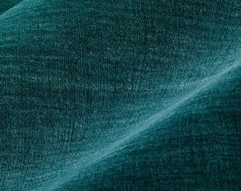 May include: A deep teal fabric with a visible woven texture and a subtle sheen. The material features a dense, consistent weave pattern with a diagonal fold creating a soft gradient of light and shadow across the surface of the textile.