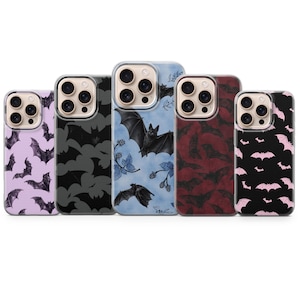 Può includere: Cinque cover per smartphone disposte in fila, ognuna con un motivo diverso a tema pipistrello. I design includono tonalità viola, nero, blu con illustrazioni di more, rosso scuro e nero con sagome di pipistrelli rosa, tutte con fori.