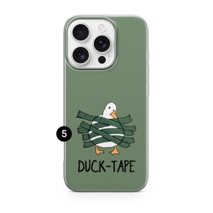 以下が含まれることがあります： セージグリーンのスマートフォンケース。オレンジ色のくちばしと足を持つ白いアヒルが、ダークグリーンのテープで巻かれているイラストが描かれています。イラストの下には黒字で「DUCK-TAPE」という文字があります。数字の5が入った小さな黒い円が表示されています。
