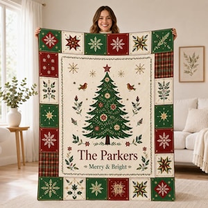 Könnte beinhalten: Eine rechteckige Wohndecke mit einem zentralen Weihnachtsbaum-Motiv, zwei Vögeln und dem Text The Parkers Merry & Bright. Der Rand besteht aus abwechselnden roten und grünen Quadraten, die mit Schneeflocken- und Karomustern verziert sind.