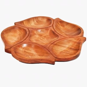 May include: A multi-sectioned wooden serving tray featuring five distinct, leaf-shaped compartments arranged in a circular pattern around a central pentagonal bowl, all displaying a natural light brown wood grain finish and smooth texture.