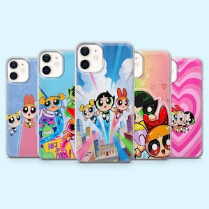 May include: A collection of five phone cases featuring the Powerpuff Girls. Each case has a different design, including the characters in various poses and scenes, with vibrant colors and cartoon graphics. The cases are made of clear plastic.