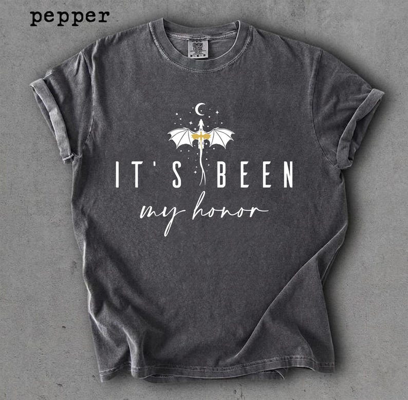 Puede incluir: Camiseta gris oscuro con mangas enrolladas. La camiseta presenta un gr&aacute;fico de drag&oacute;n y el texto "IT'S BEEN my honor" en blanco. La palabra "pepper" est&aacute; en la esquina superior izquierda.