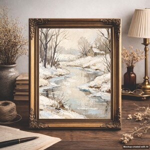 Könnte beinhalten: Ein Ölgemälde in einem dekorativen Goldrahmen, das eine Winterlandschaft mit einem schneebedeckten Fluss, kahlen Bäumen und einer kleinen Hütte in der Ferne zeigt. Die Farbpalette besteht aus sanften Weiß-, Creme-, Grau- und Blautönen.