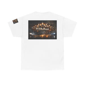 Può includere: T-shirt bianca con grafica sul retro. La grafica include il testo "TEEBalloon" sopra un'immagine di una corona e uno skyline cittadino. Un piccolo disegno è sulla manica sinistra.