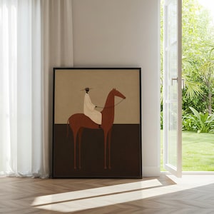 May include: Framed art print featuring a minimalist illustration of a person riding a brown horse. The rider is wearing a white garment and a hat. The artwork has a neutral color palette with a tan background and a dark brown lower section.