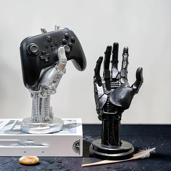 A mechanical cyberpunk robot hand cast in resin that doubles as a headset/controller stand — functional desk art that looks like it escaped a sci-fi prop room.