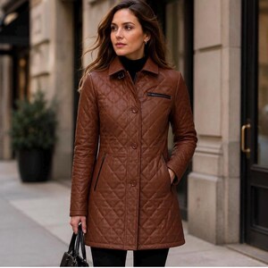 May include: A brown quilted leather jacket featuring a classic collar, a front button closure, and a zippered chest pocket. The jacket has a diamond-stitched pattern throughout the body and sleeves, providing a structured look with long sleeves.