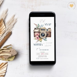 May include: A digital phone screen displaying a birthday invitation for Sophia's thirteenth birthday. The invitation features a vintage camera with floral accents and the text "Oh Snap, Sophia is turning thirteen. You're invited to celebrate... November 25th at 12:30pm. 1234 Floral Camera Drive, Woodland Hills, CA 90005. RSVP to Leah at (310) 343-6789."