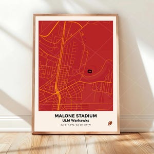 May include: A framed vertical poster featuring a red map of the area surrounding Malone Stadium. The map displays yellow street lines and a small black stadium icon. Text reads: MALONE STADIUM, ULM Warhawks, 32°31'48"N, 92°04'05"W, with a football icon.