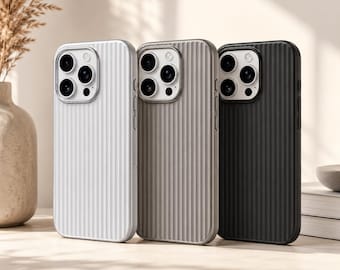 May include: Three phone cases in white, gray, and black. Each case has a vertical ribbed design and a camera cutout with multiple lenses. The cases are standing upright on a light-colored surface.